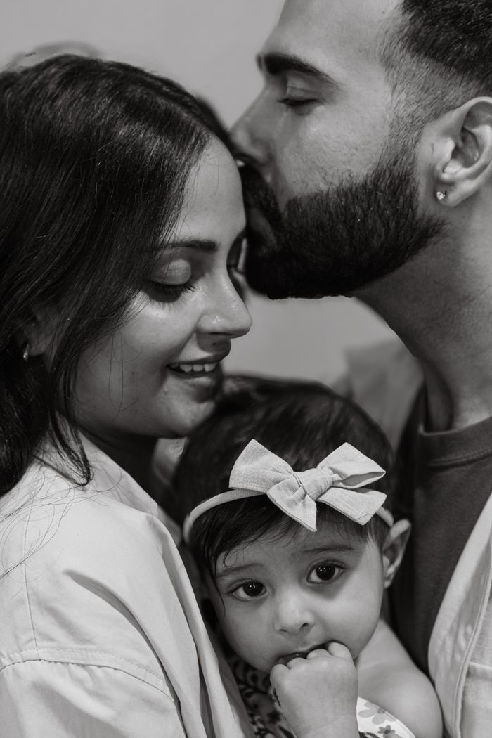A heartfelt black and white portrait of a loving family with a baby.