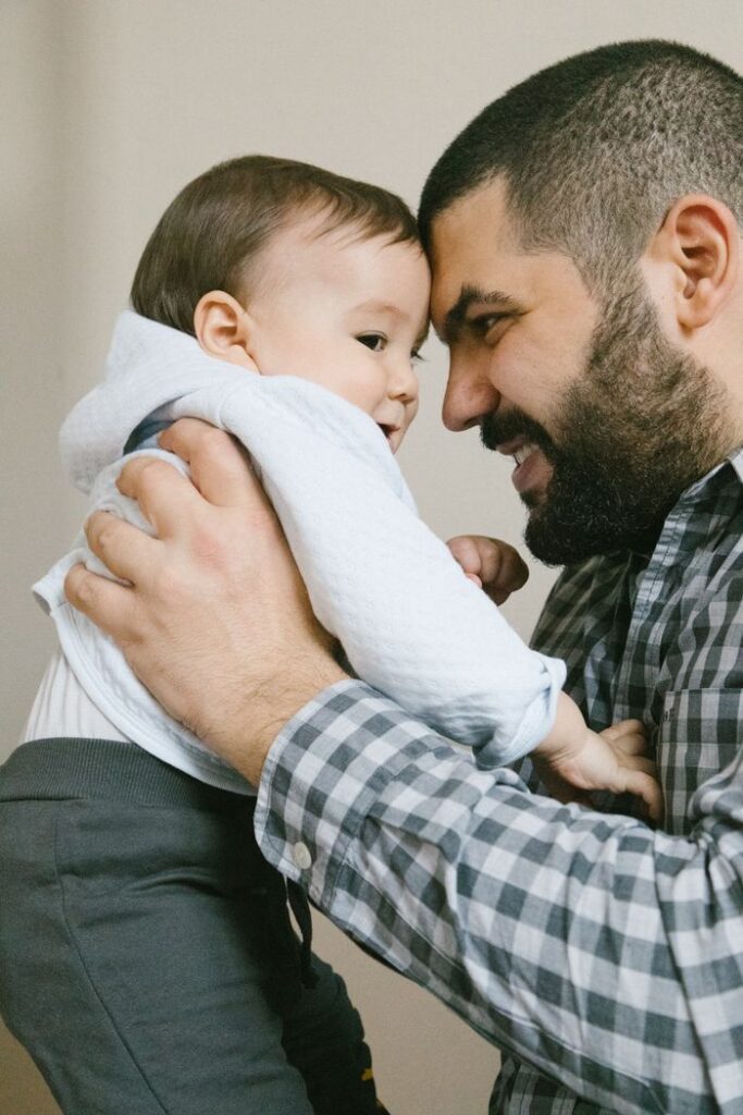 A joyful moment between a father and son indoors, showcasing love and happiness.
