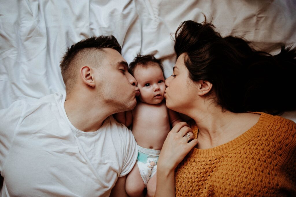 Parents lovingly kiss their child and ready for Paternity DNA Test Trio