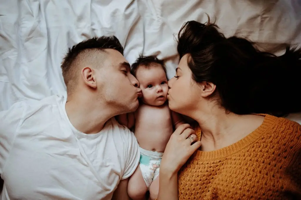 Parents lovingly kiss their child and ready for Paternity DNA Test Trio